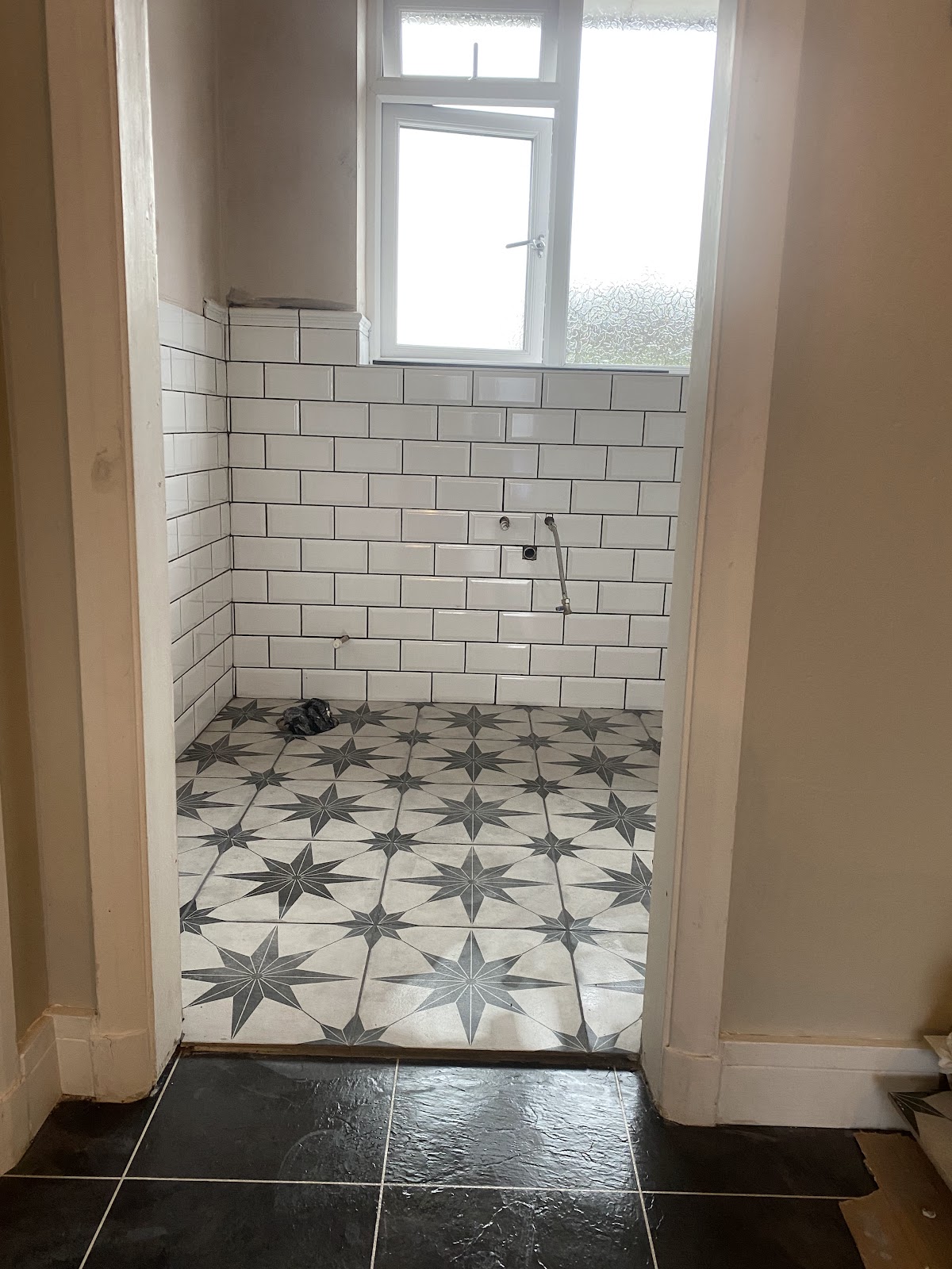 Star-pattern porcelain floor with white metro wall tiling