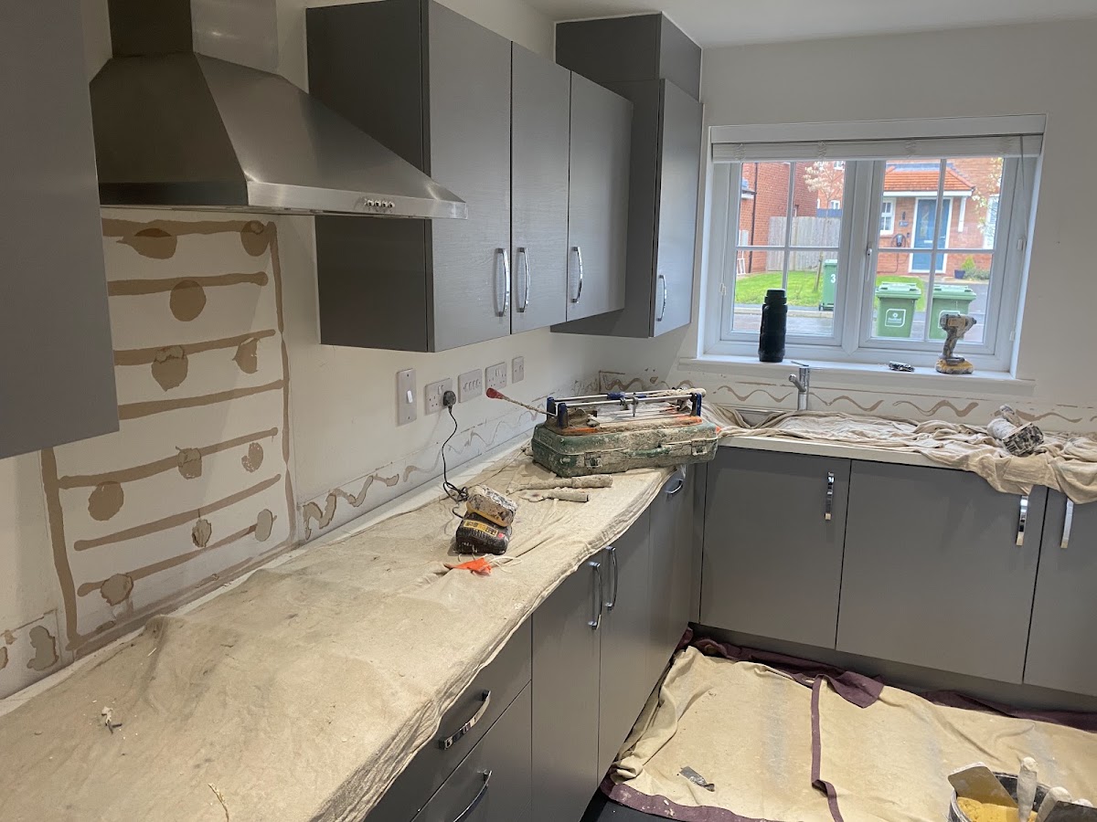 Grey kitchen splashback mid-installation