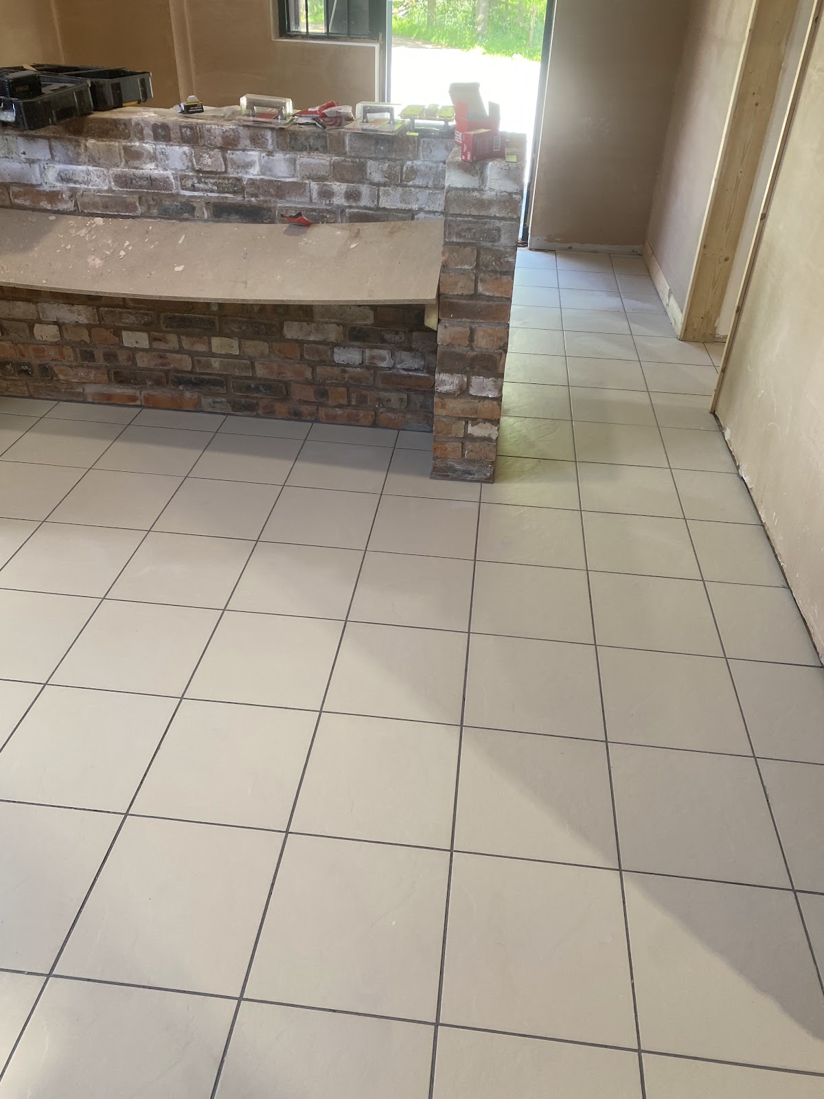 Cream porcelain floor tiling beside an exposed brick feature
